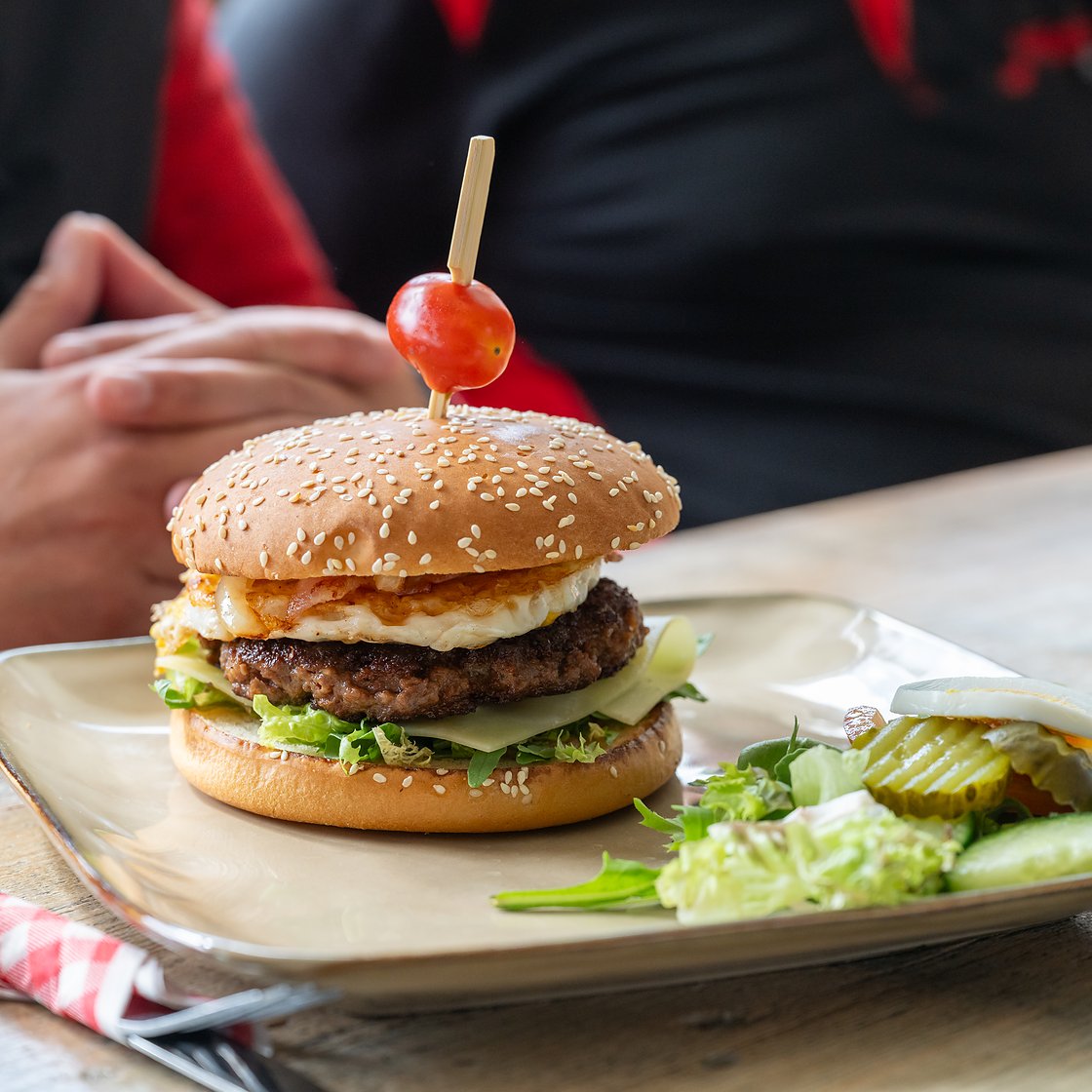 een Frysk black angus burger met gebakken ei en spek, met een frisse salade erbij
