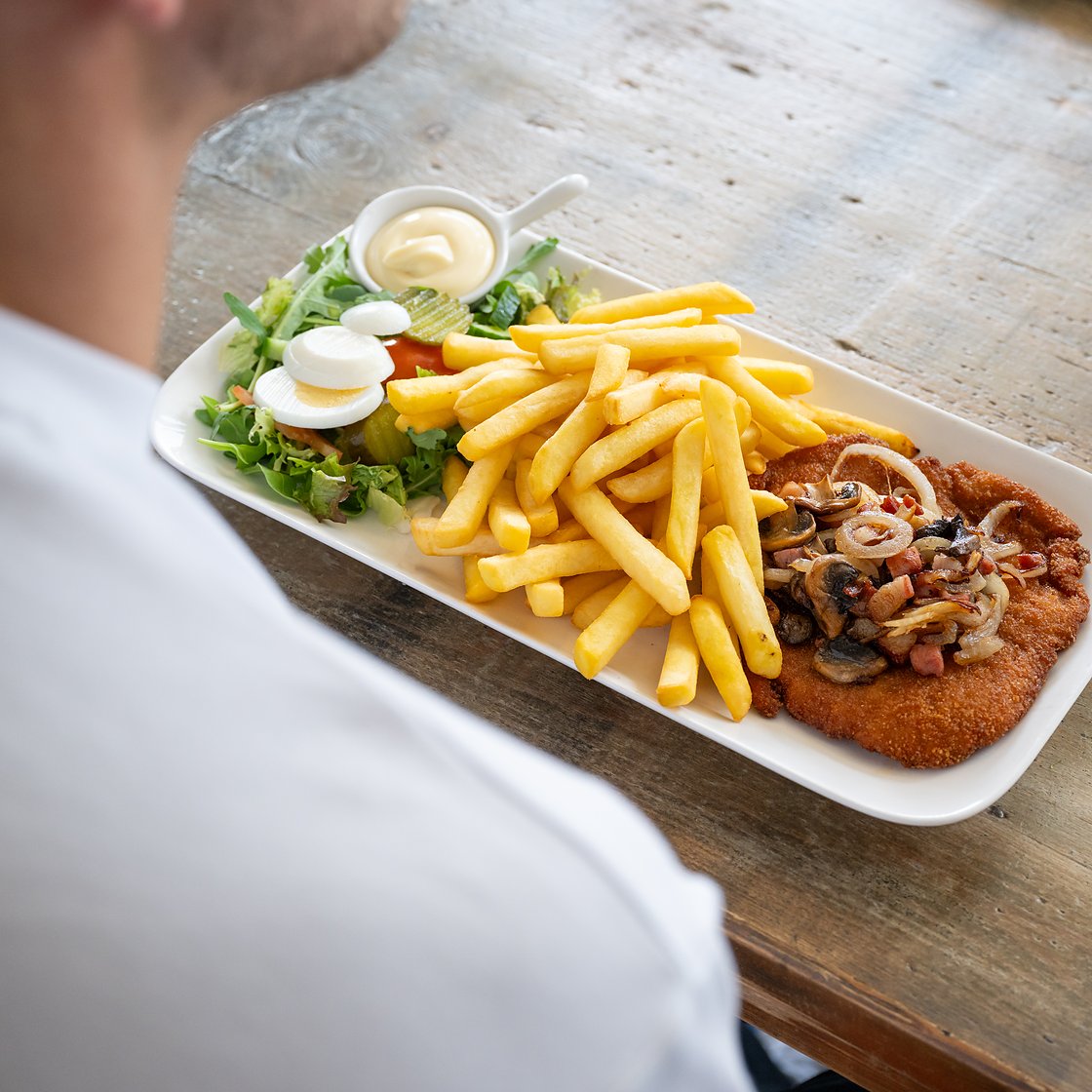 een plate schnitzel met friet en frisse salade