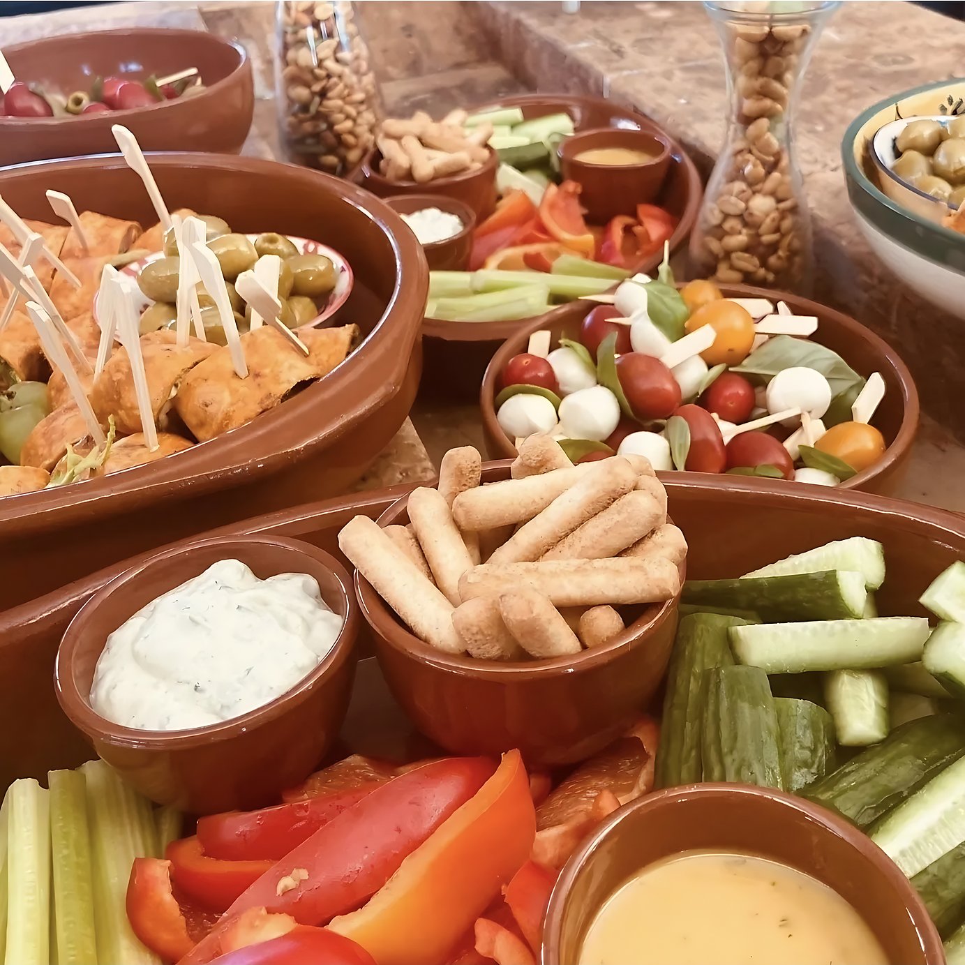 schalen met rauwkost, dipsauzen, soepstengels en spiesjes met tomaat en mozzarella