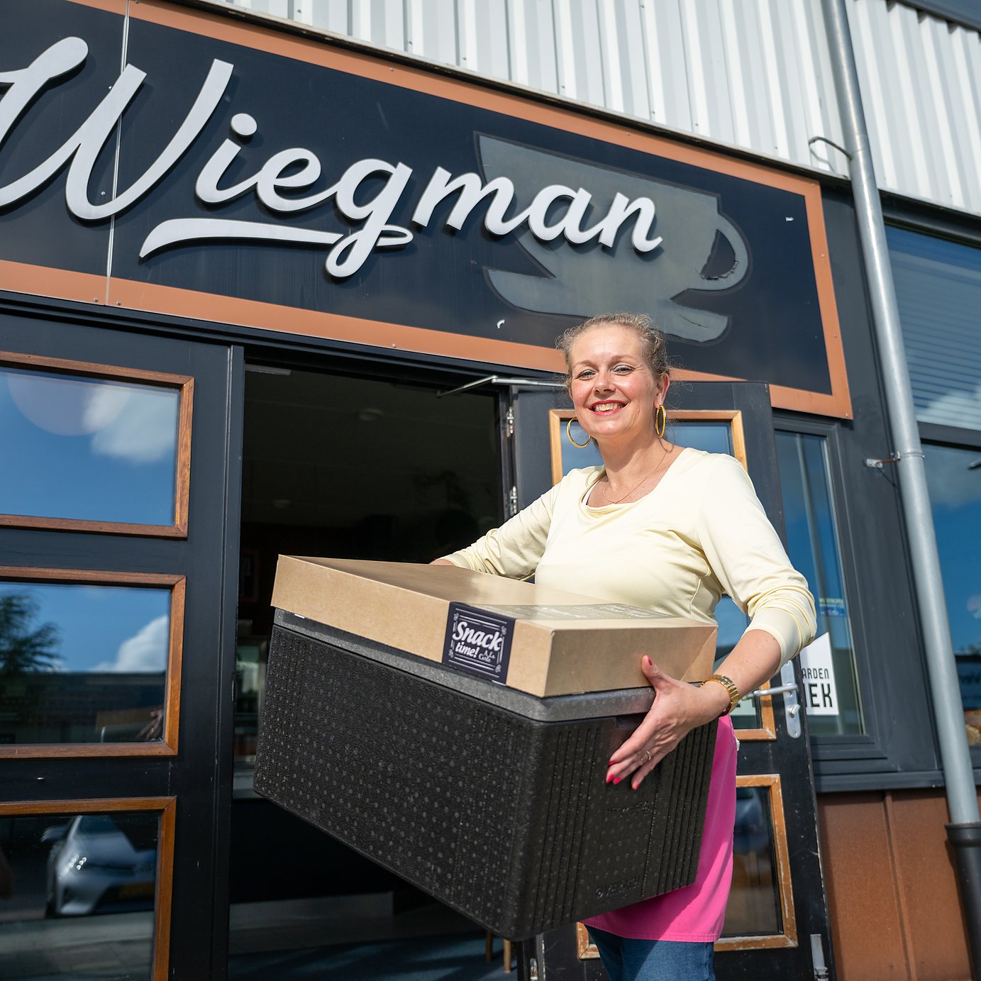 een medewerker van Eetcafé Wiegman brengt een lunchbestelling naar buiten voor bezorging op De Zwette in Leeuwarden