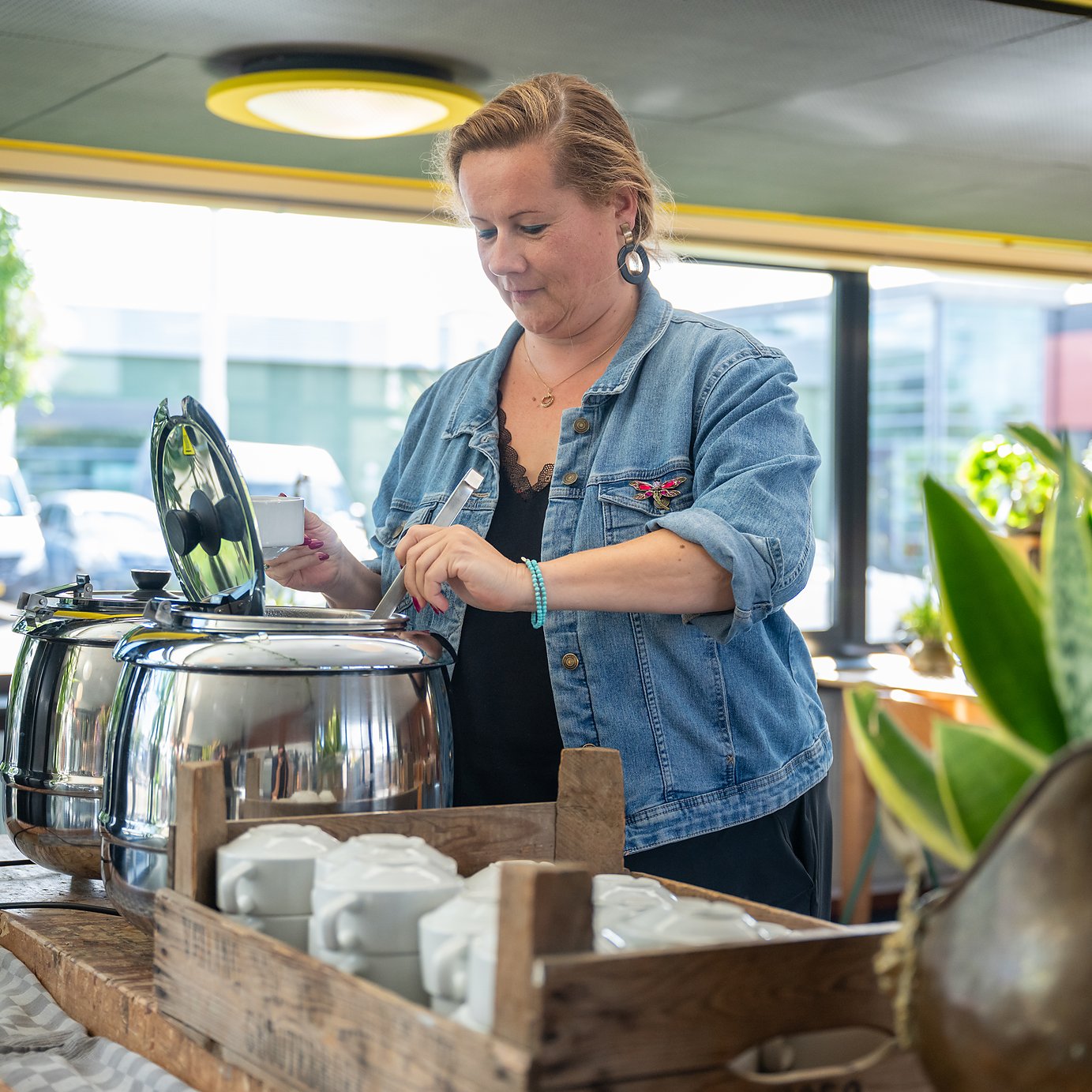 soep wordt opgeschept uit de soepketels, met de kommen klaar in een houten kist