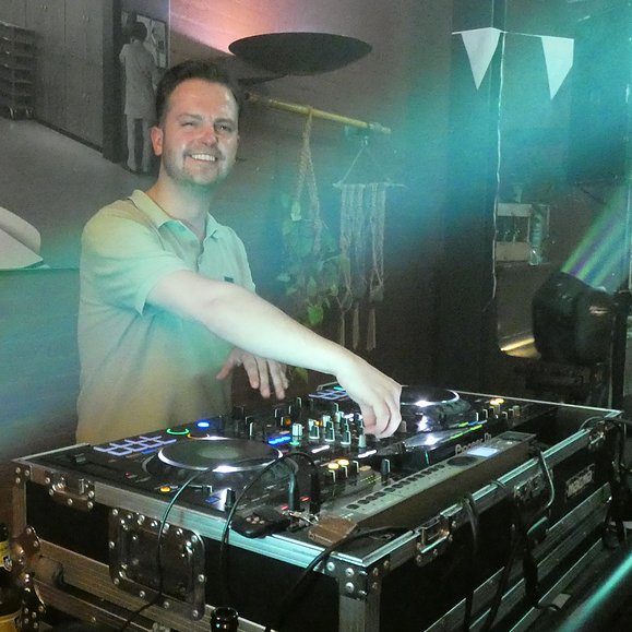 een dj achter de draaitafels tijdens een feestavond in Eetcafé Wiegman